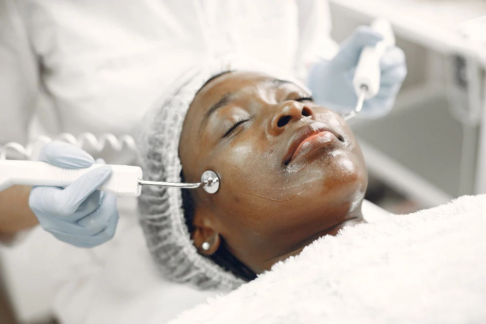 Woman receiving non-invasive laser skin tightening treatment for firmer, youthful-looking skin